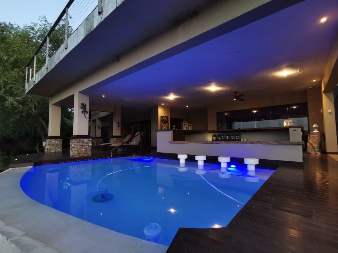 The lodge pool at dusk, with warm lights spilling from the lodge