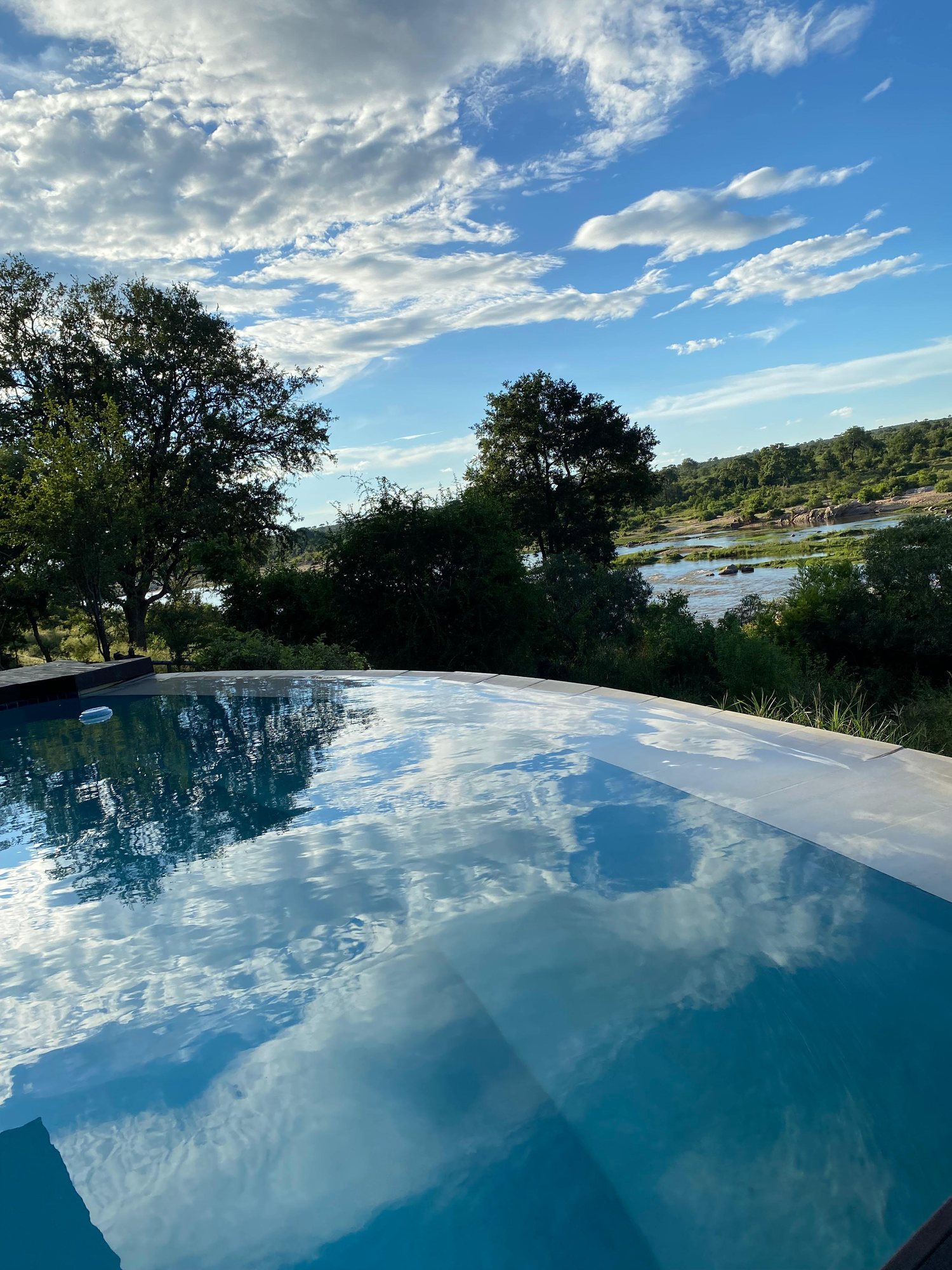 The infinity pool with the sky reflected in its surface